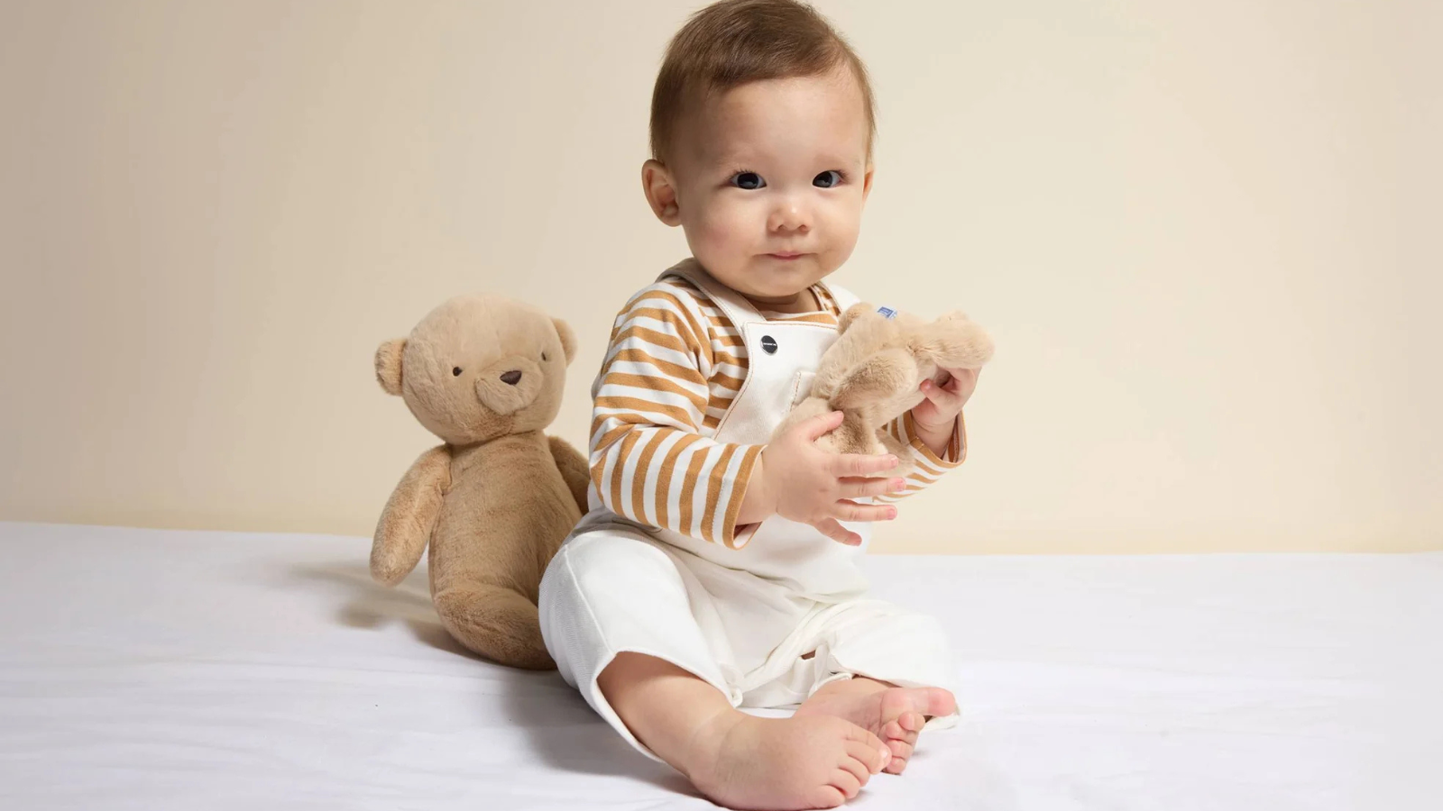 Elegant luxury baby clothes displayed for gifting, featuring soft pastels and boutique newborn outfits