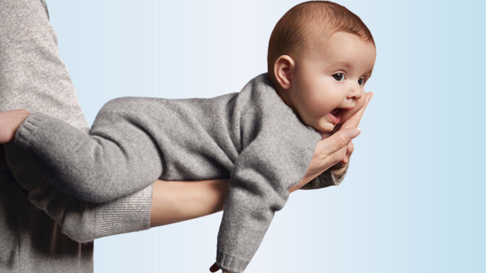 Elegant newborn baby clothes displayed on soft bedding, showcasing luxury baby clothes in neutral tones
