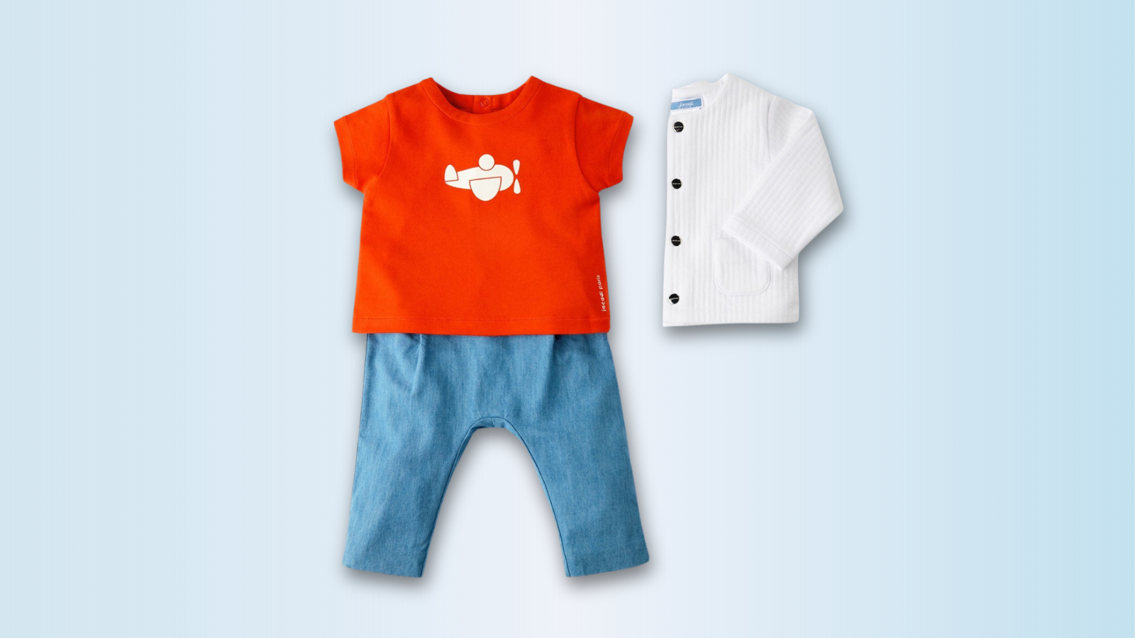 Elegant children's clothing gift display featuring luxury kidswear pieces in soft pastels and classic designs